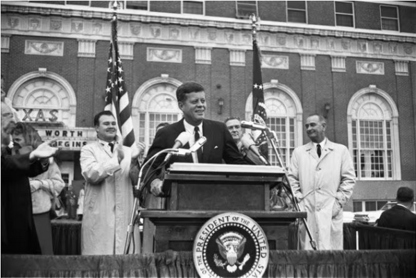In this Nov. 22, 1963, photo provided by the The Sixth Floor Museum at Dealey Plaza, John F. Kennedy speaks outside the Hotel Texas in Fort Worth. When Kennedy took office he soon realized he had much to learn. So he pursued crash courses in foreign and economic policy, and never stopped improving in those critical areas until the day he died, writes Talmage Boston.